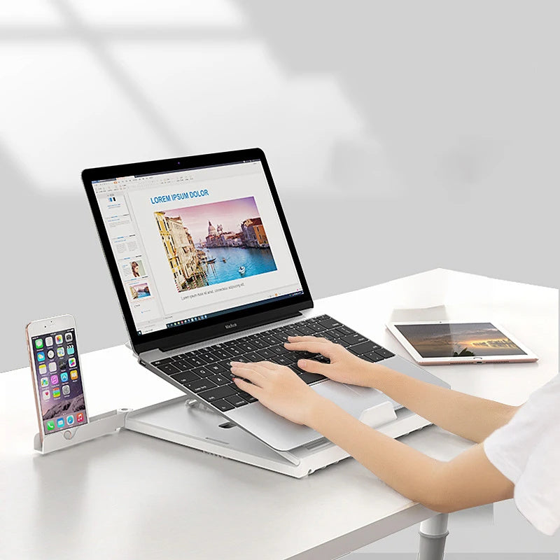 Sheluxe portable laptop stand adjustable holding a laptop with a phone docked on the side on a white desk