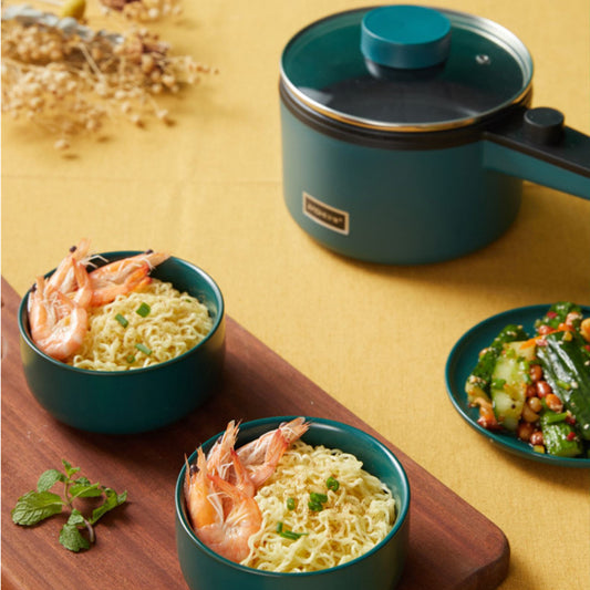 Nutritea portable electric pot for dorm with green exterior shown with noodles and shrimp served in matching bowls
